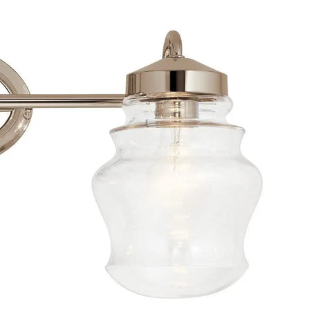 Close-up of a clear glass shade fixture from Janiel 24 Inch Three Light Vanity Light With Clear Glass Shades In Classic Bronze Finish