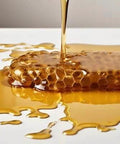 Honeycomb with dripping golden honey on a smooth surface, illustrating the nonstick quality of Terpene-Resistant PTFE Roll For Chef-Grade Kitchens And Lab-Precision Extractions.