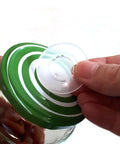 aPraktika vacuum valve for food jars; transparent valve being installed into a green lid.