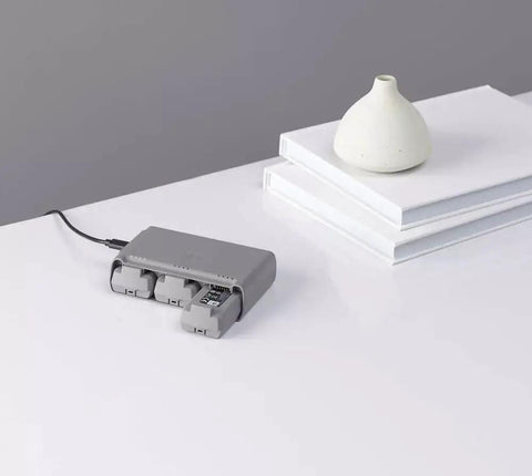 Three Battery Two Way Charging Station Hub For Mini 2 Drone with three batteries connected on a white table.