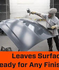 Person spraying a car hood with paint in a workshop, emphasizing surface readiness for finishing.