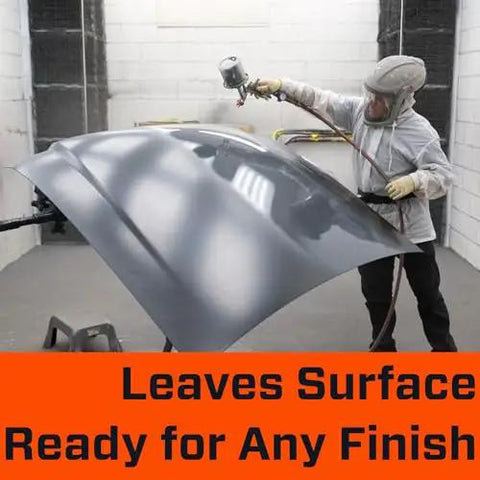 Person spraying a car hood with paint in a workshop, emphasizing surface readiness for finishing.
