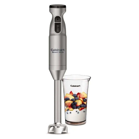 Heavy Duty Corded Stick Blender With Two Speed Toggle Makes Silky Smoothies And Creamy Broths In A Jiffy With Whisper Quiet Motor In Sleek Silver next to a cup of mixed fruit.