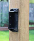 Top Shelf Heavy Duty Privacy Fence Brackets For Standard 2x4 Wood Railings Pre Drilled Galvanized Steel 8 Pack mounted on a wooden post.