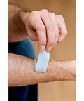 Close-up of blue adhesive medical tape being applied to a forearm