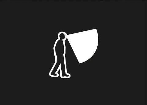 Silhouette of person using Tikkina Compact Headlamp With 300 Lumen Brightness for hiking with visible light beam.