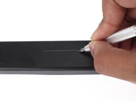 User marking a black surface with Heavy Duty Tungsten Carbide Scriber Engraving Pen For Marking Steel Metal Wood.