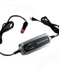 Porsche Charge O Mat Pro Battery Maintainer and Charger for cars with 12V cigarette lighter plug, shown with cables and plug.