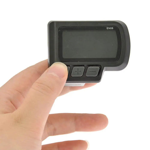 Hand holding EN06 display from Waterproof Bike Computer With LCD Screen And Speedometer For Electric Bikes And Scooters