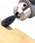 Close-up of black metal rotary burr in a drill chuck used for wood carving