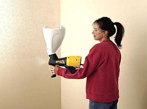 Pro Grade Electric Texture Sprayer Featuring Three Ready To Roll Swappable Nozzles For Acoustical Popcorn Knockdown Orange Peel Coatings On Ceilings Walls Fast Lock N Go Setup Makes Weekend Renovations A Breeze in use on a wall.