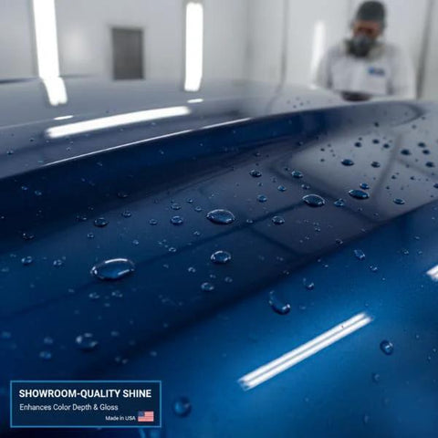 Front view of blue automotive clear coat finish on a car hood with water droplets; label visible