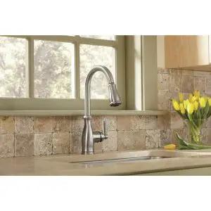 Traditional One Handle Kitchen Faucet In Spot Resist Stainless With Pull Down Sprayer Power Boost Quick Rinse Reflex Retractable Hose Dead Simple Install Slick Steel For Everyday Upgrades displayed in a kitchen setting with flowers.