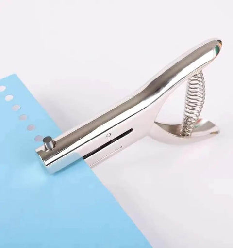 Tough As Nails Single Hole Punch for Crafts and Scrapbooks, quarter inch zinc alloy hole puncher used on blue paper.