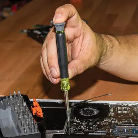 Person using All In One Precision Screwdriver Set With 39 Bits For Apple Devices Magnetic Dual End Barrel For One Handed Fastener Retention Case Included Klein Tools Pro Repair Kit For Tech Enthusiasts to repair electronics.