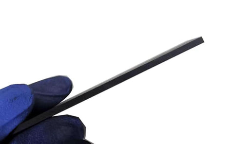 Side view of a machinist grade graphite plate for EDM and milling 100mm by 100mm by 2.54mm, showcasing its thin profile and precision edge.