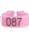 Close-up of pink 8mm Plastic Pigeon Leg Bands Rings with number 087, part of the 100 Count Bag with six color options.