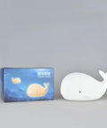 Under The Sea Nursery Night Light Whale Lamp for Baby and Toddler Room beside packaging box on gray background.