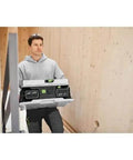 A worker carrying a Cordless Table Saw With Battery Powered Circular Blade For Drop Dead Accurate Miter And Parallel Cuts Compact Portable Benchtop Tool.