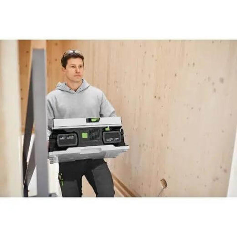 A worker carrying a Cordless Table Saw With Battery Powered Circular Blade For Drop Dead Accurate Miter And Parallel Cuts Compact Portable Benchtop Tool.