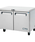 Top Shelf Polished Stainless Steel 48 Inch Undercounter Work Top Freezer Featuring Rock Solid Forced Air Cooling Digital Temp Display Slick Design Ready To Roll, showing stainless steel finish and mounted casters.