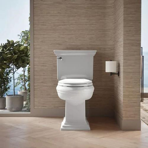 White elongated toilet, front view, installed in a modern bathroom with wood-paneled walls.