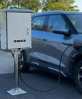 Tough As Nails Waterproof EV Charger Box Cover With Lockable Electric Vehicle Charging Station Enclosure on outdoor pedestal next to car.