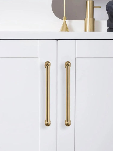 Two Pack 12 Inch Center To Center Brushed Brass Cabinet Pulls installed on white cabinet doors