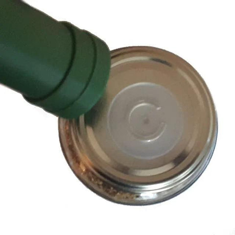 aPraktika vacuum valve with green nozzle installed on a shiny metal jar lid