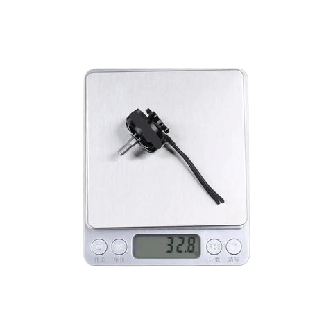 2207 Brushless Motor 1800Kv 2450Kv 2750Kv for 2 to 6S Drones on digital scale showing 32.8 grams