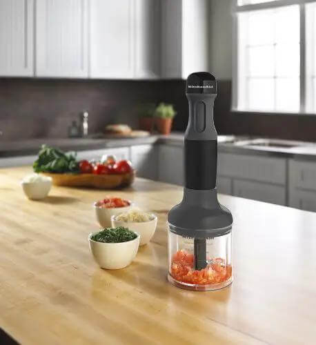 Powerhouse 3 Speed Hand Blender With Soft Grip Handle In Onyx Black Includes Removable Blending Arm Whisk Attachment And BPA Free 2 Cup Chopper Bowl on kitchen table with chopped veggies