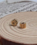 Two Pack Brass Spur Gears, 0.5 Modulus, 12 Teeth, 3mm Bore, 5mm Gear Width on wooden surface.