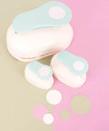 Three sizes of 3 Inch Circle Scallop Punch With Easy Lever Press, shown against a pink and green background with scalloped cutouts.