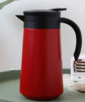 Heavy Duty Stainless Steel Vacuum Flask With Secure Handle Leakproof Travel Mug on a green tabletop.