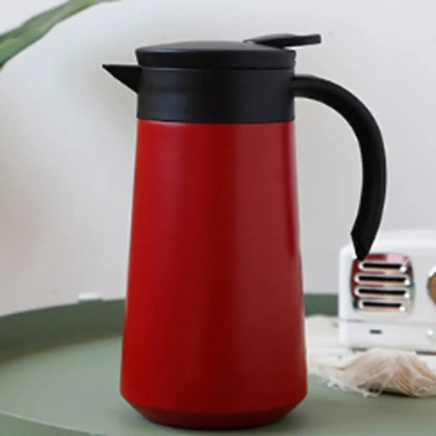 Heavy Duty Stainless Steel Vacuum Flask With Secure Handle Leakproof Travel Mug on a green tabletop.