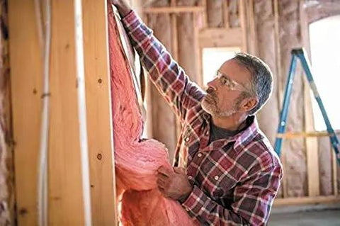 Top Ticket R-13 Pink Kraft Faced Fiberglass Insulation Roll Crafted For Smooth Sailing 2by4 Wall Install To Lock In Warmth Dead Silence And Keep Your Place Snug Year Round Formaldehyde Free Ultra Comfortable Triple Pack being installed by a man.