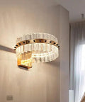 Top Tier Led Crystal Wall Sconces With A Clean Neoclassical Look And A Smooth Glare Free Glow, mounted on a wall with warm lighting.