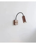 Modern Walnut Wall Sconce With 360 Degree Swivel Spotlight on a wall, showcasing a sleek design and adjustable beam control.