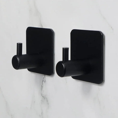Side view of two black Heavy Duty Adhesive Aluminum Hooks, 12 Pack Black Wall Mount Hooks for hanging on marble wall