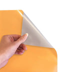 Hand peeling back the top layer of Electric Yellow EasyWeed HTV Heat Transfer Vinyl 11.8 by 3ft Roll for Crafts.