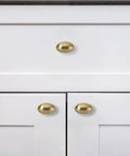 Close-up of Ten Pack Of 1-3/8 Inch Brushed Brass Cabinet Knobs Built Hella Sturdy With Zinc Alloy And Copper Finish on white cabinet doors.