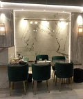 Sleek Vertical Wall Sconce With Rectangular Glass Shade illuminating a modern dining area with green chairs and marble walls.
