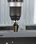 Step Drill Bit Set 5 Piece With Fifty Sizes HSS Titanium Coated Step Bits drilling into metal surface in industrial setting