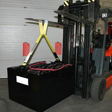 Industrial forklift battery lifting sling, front view, yellow straps lifting a large black battery beside a forklift.