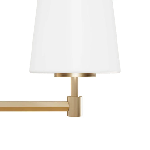 Close-up of Nolita Vanity Light with Alturas Gold finish and cased white glass, featuring durable steel or aluminum construction.