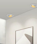 Two UWYTGF 10 Pack 4.5 Inch Gimbal Led Recessed Lights in a ceiling, providing warm illumination over a wall art display.