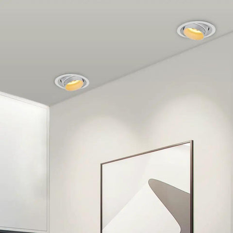 Two UWYTGF 10 Pack 4.5 Inch Gimbal Led Recessed Lights in a ceiling, providing warm illumination over a wall art display.