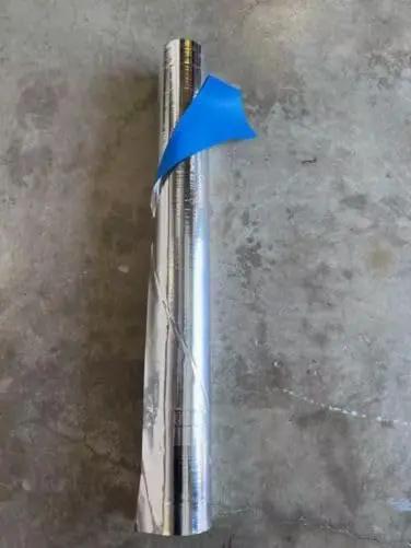 Four By Two Hundred Fifty Foot Synthetic Roof Underlayment Pro Grade Heavy Slick Roll showing blue peel-off film on a silver roll.