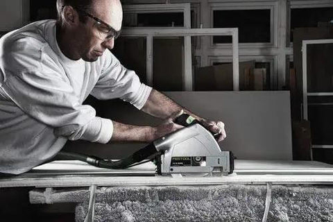Pro Shop Ready Track Saw Delivering Heavy Duty Performance With 1200 Watt Motor And Hella Precise Negative One To Forty Seven Degree Bevel Cuts Plus Smooth Operation Guide Rail System used by a tradesman on a work table.