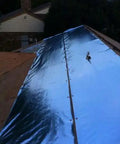 Four By Two Hundred Fifty Foot Synthetic Roof Underlayment Pro Grade Heavy Slick Roll installed on a sloped roof, reflecting sunlight.